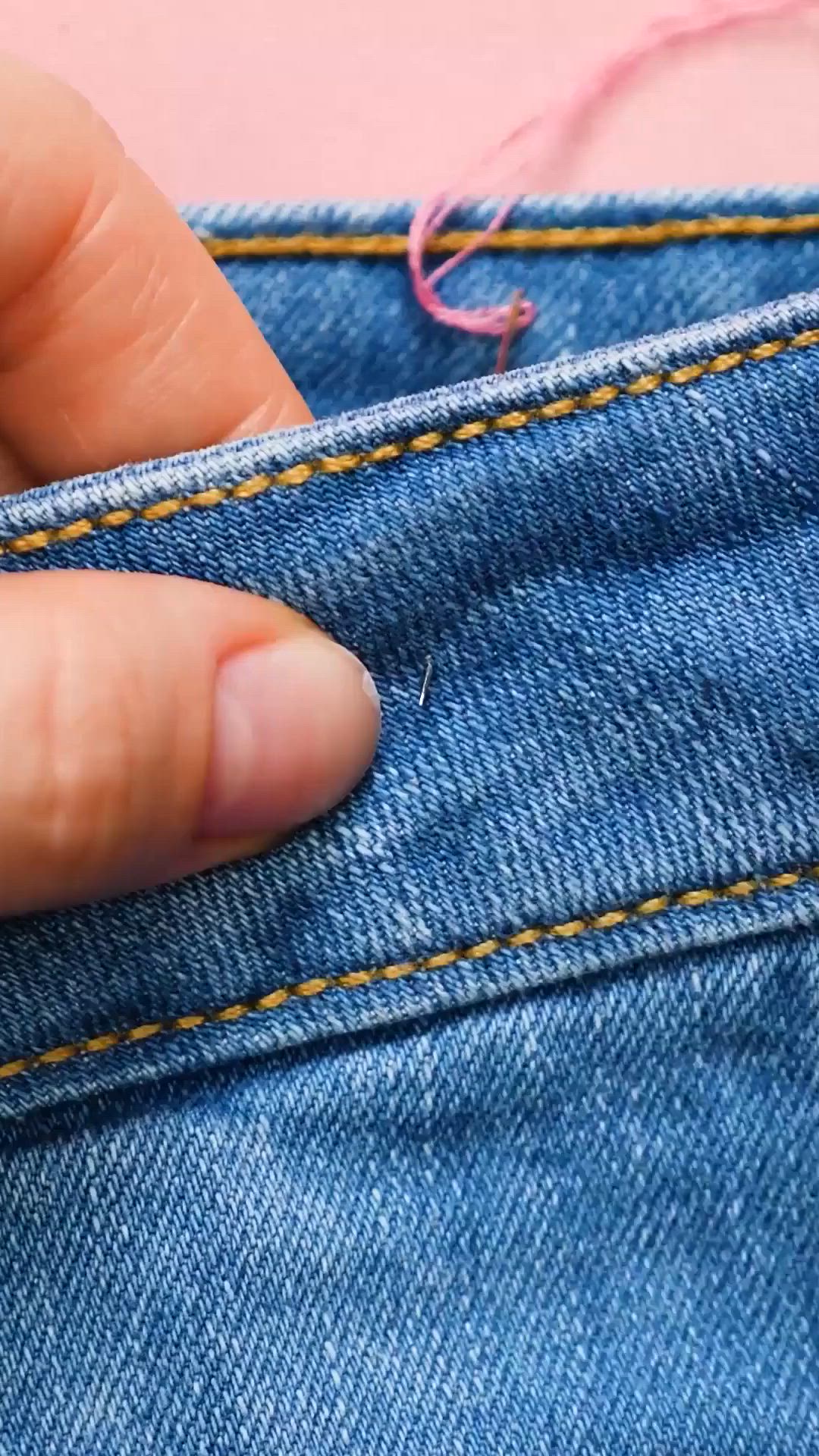 This may contain: someone is stitching the thread on their jeans