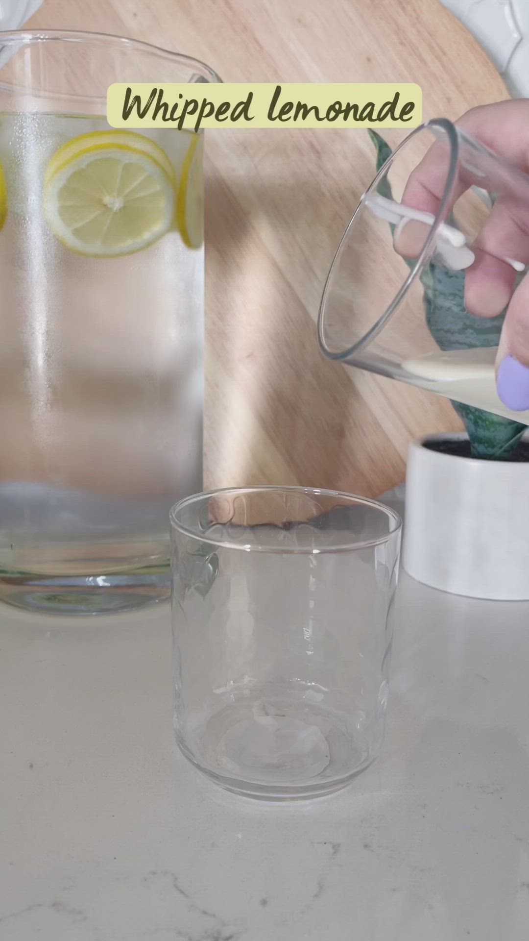 This may contain: a glass filled with lemonade sitting on top of a table