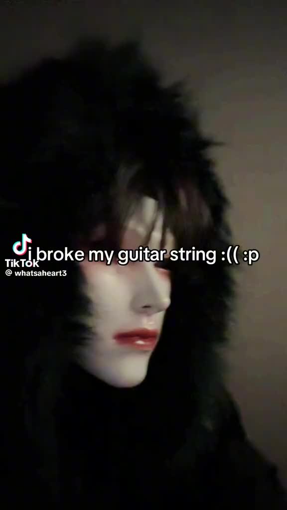This may contain: a woman with black hair and white make - up is shown in the dark text reads broke my guitar string lp