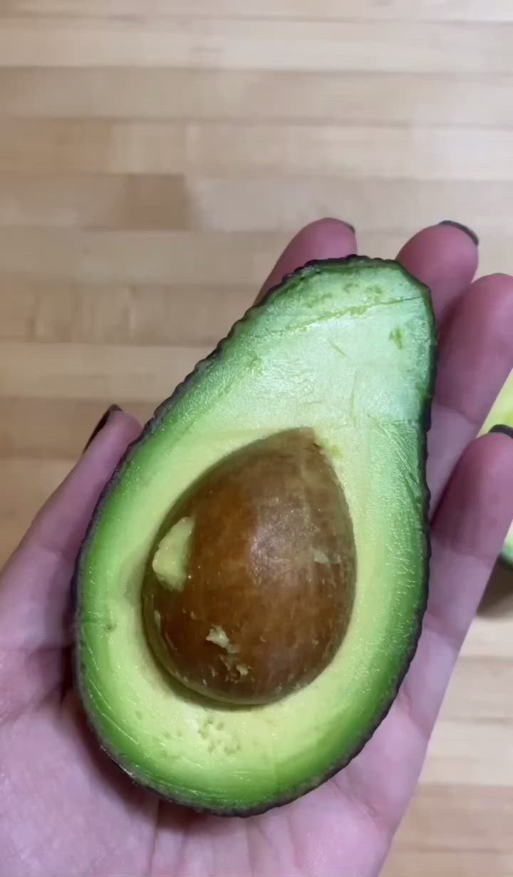 This may contain: someone holding an avocado in their hand