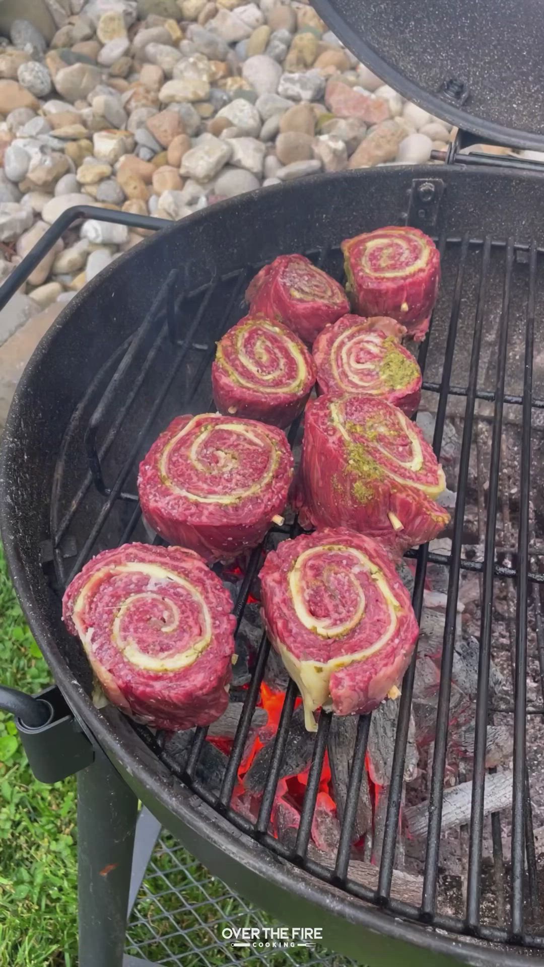 This may contain: meatloaf rolls cooking on the grill outside