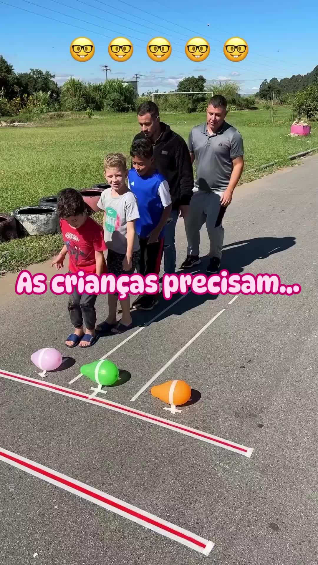 This may contain: three adults and two children are standing in front of an outdoor game set with balls