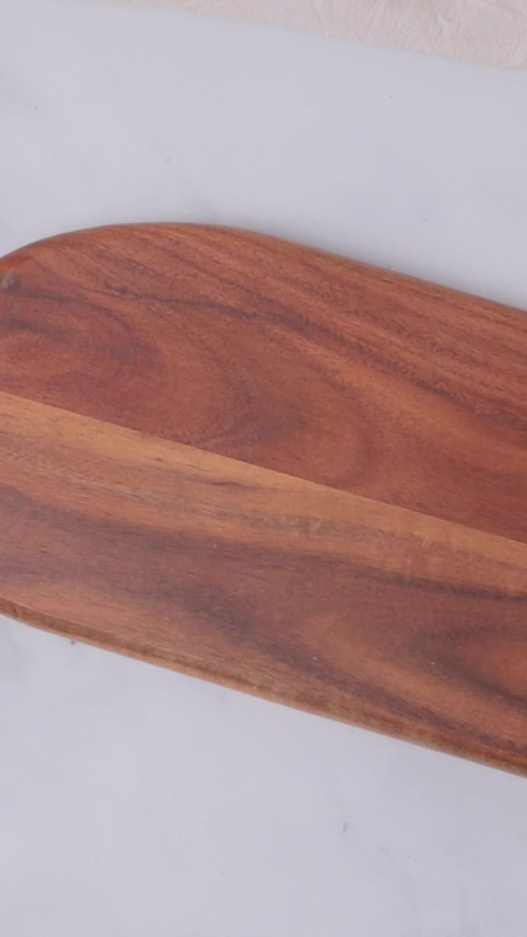 This may contain: a wooden cutting board sitting on top of a white counter