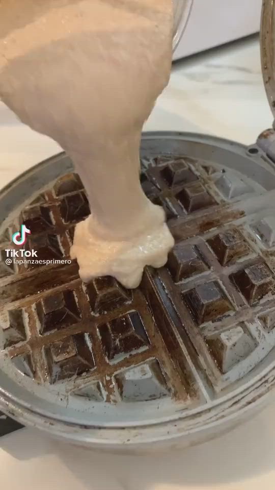 This may contain: a waffle maker being used to make chocolate