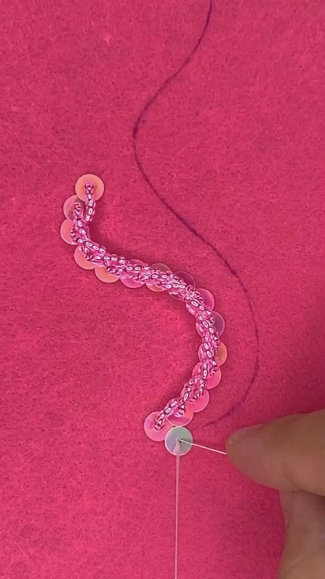 This may contain: someone is making something with pink thread and buttons