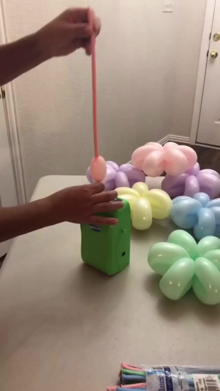 This may contain: a person holding a toothbrush in front of some balloons on a table with other items