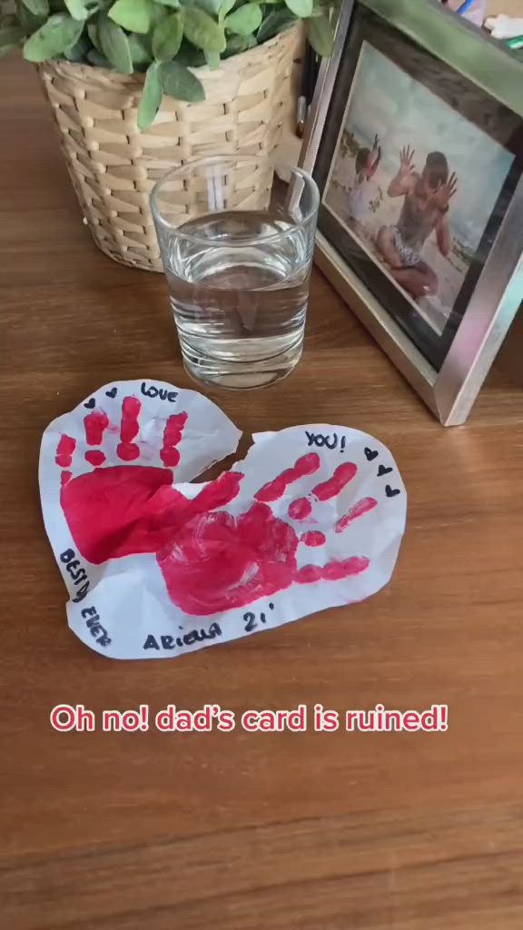 This may contain: someone is holding up a handprinted heart for their father's day card