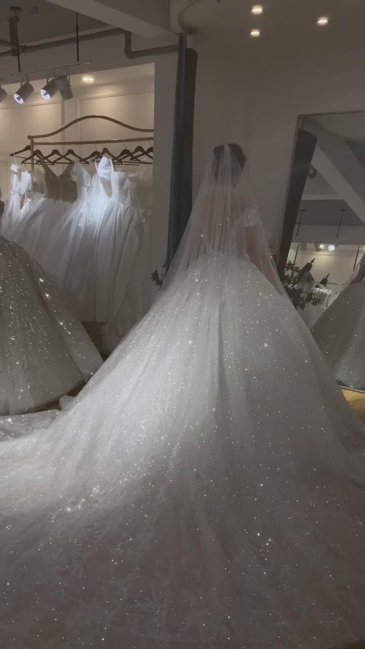 This may contain: a bride's wedding dress is on display in a store with other bridal gowns