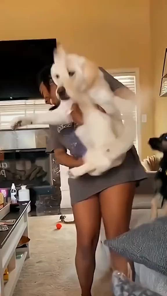 This may contain: a woman is dancing with her dog in the living room