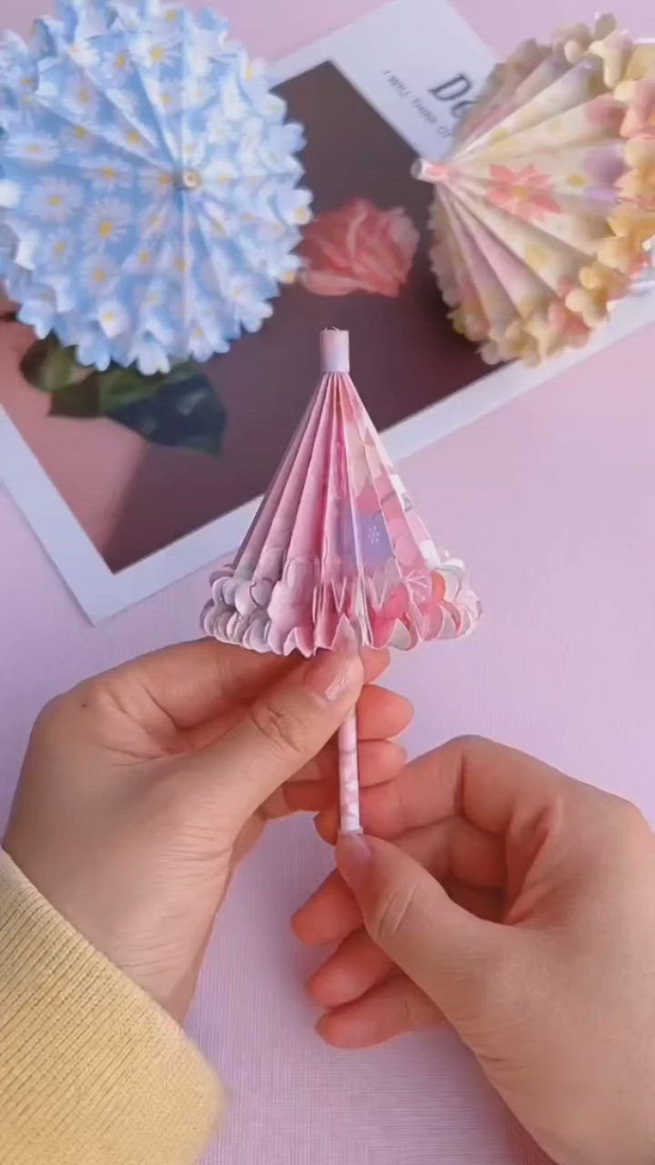 This may contain: a person's legs with paper flowers on their ankles and one hand holding an origami fan