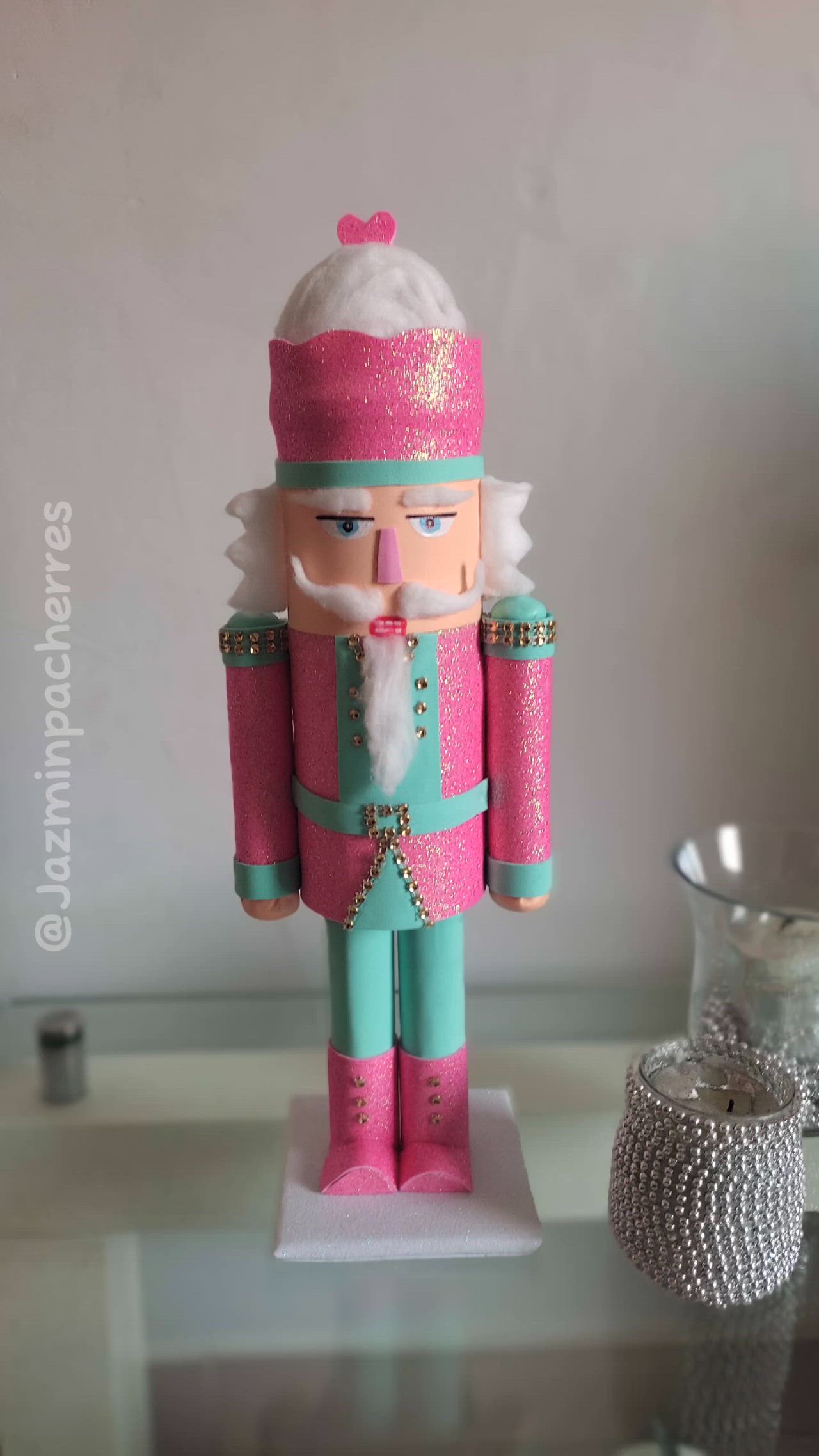 This may contain: a pink and blue nutcracker is sitting on a table