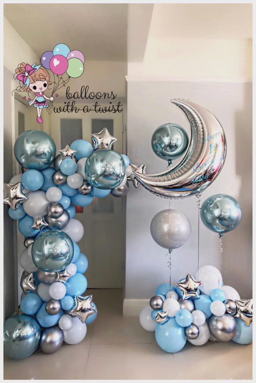 This may contain: balloon arch with moon and stars hanging from it's sides in blue, silver and white colors