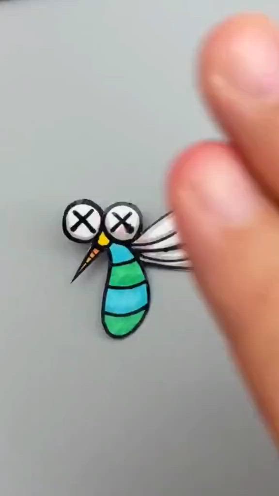 This may contain: a person is holding a small pin with a bee on it