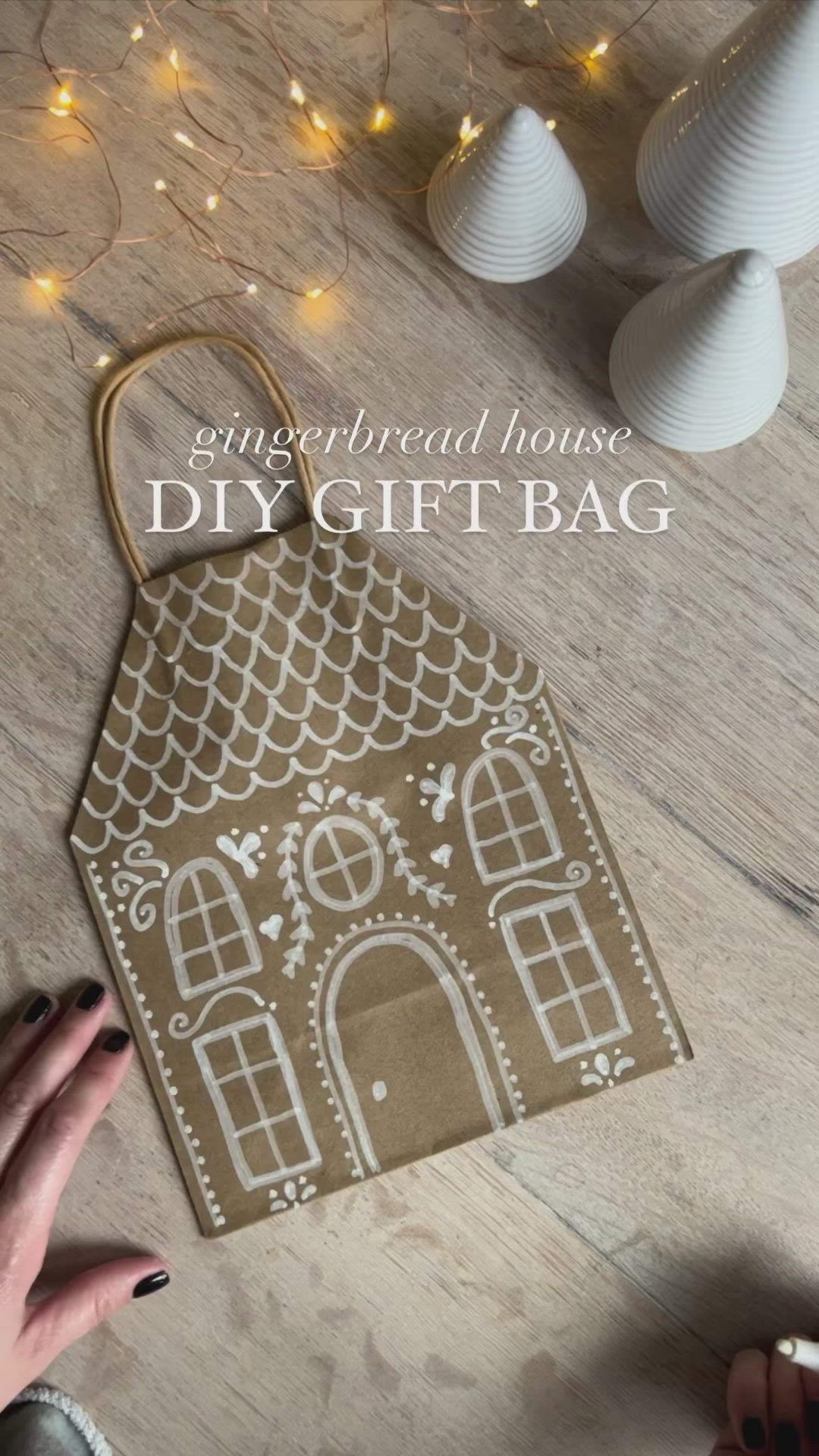 This may contain: the gingerbread house diy gift bag is sitting on top of a wooden table