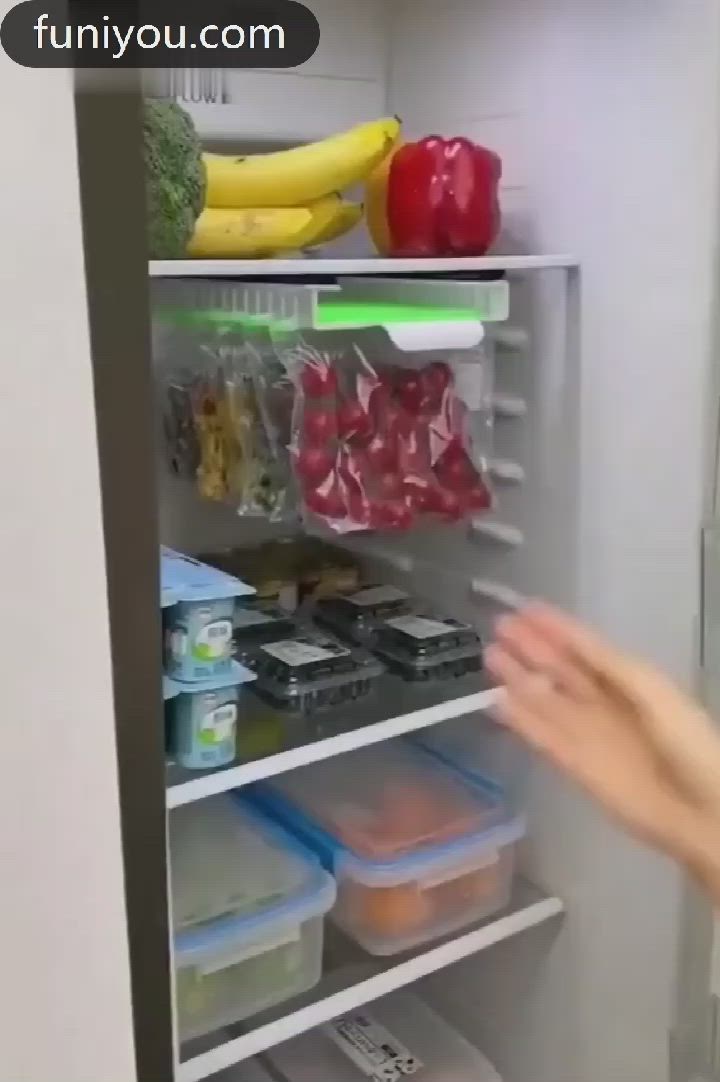This may contain: a person reaching for food in a refrigerator