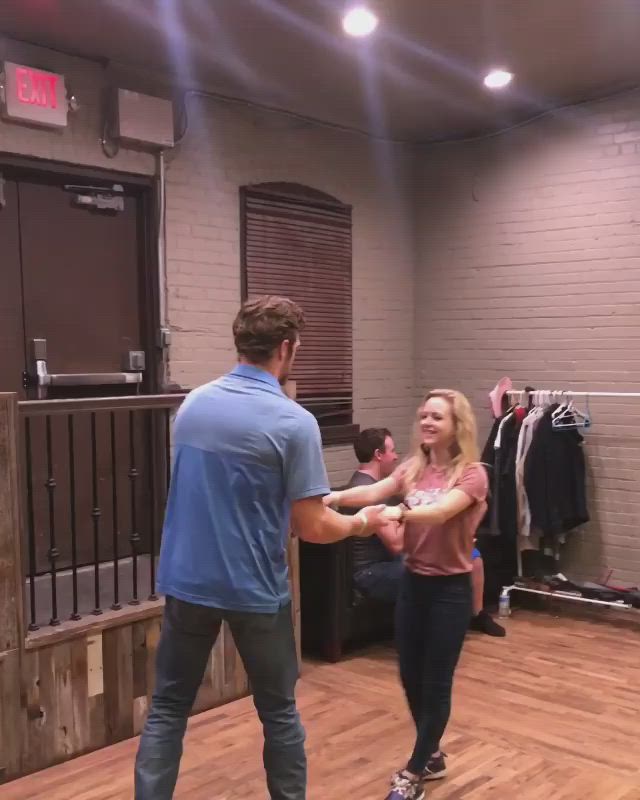 This may contain: a man and woman dancing in a dance studio