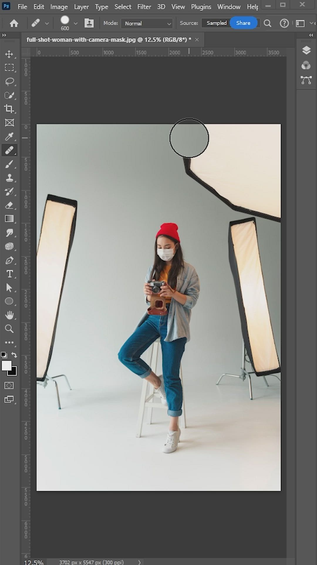 This may contain: a woman is sitting on a chair in front of two lights and holding a cell phone