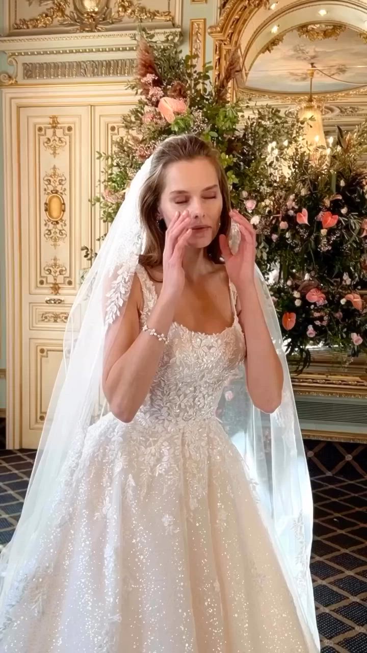 This may contain: a woman in a wedding dress posing for the camera