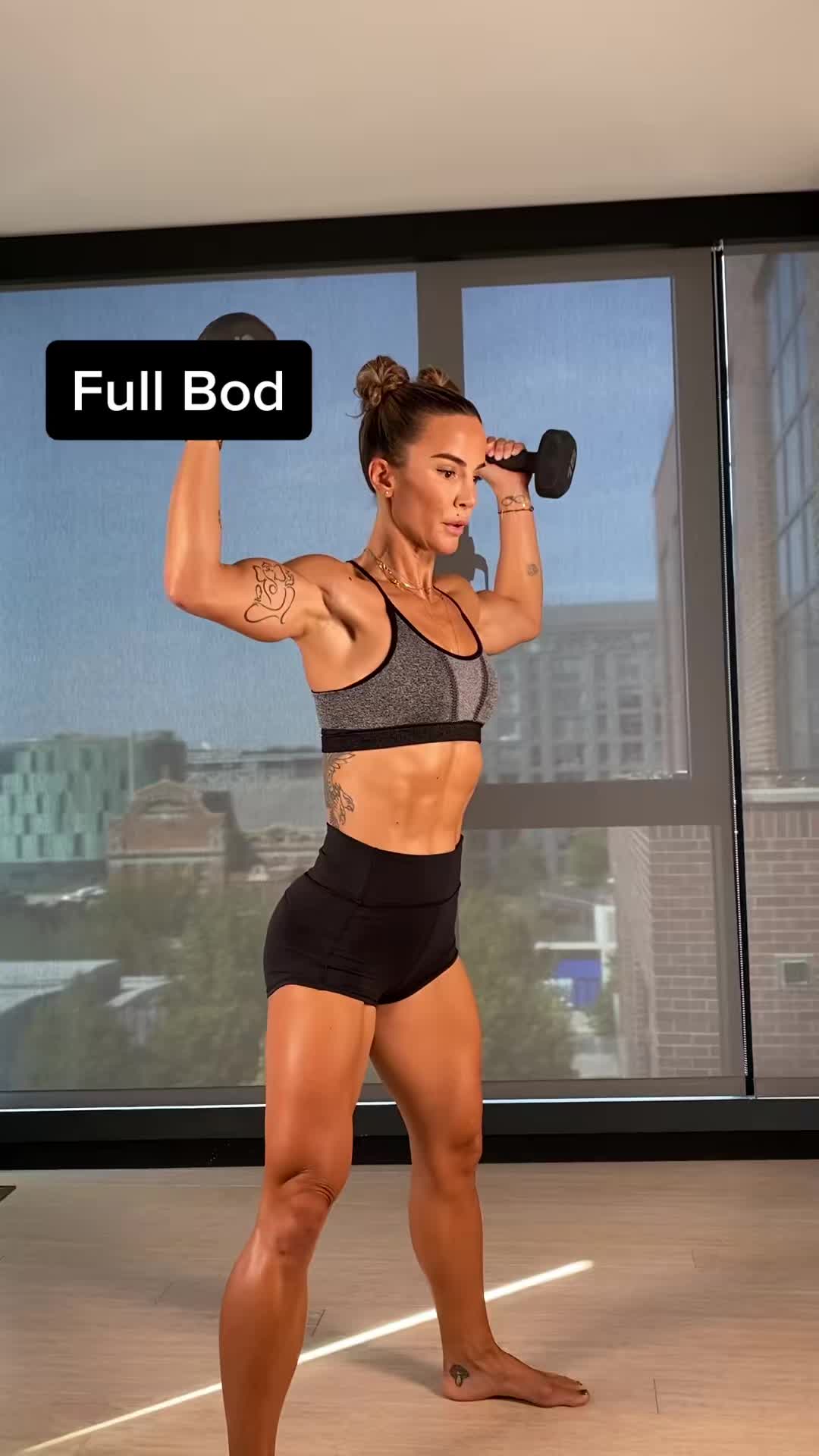 This may contain: a woman is doing exercises with dumbbells in front of a window and the words full bad above her head