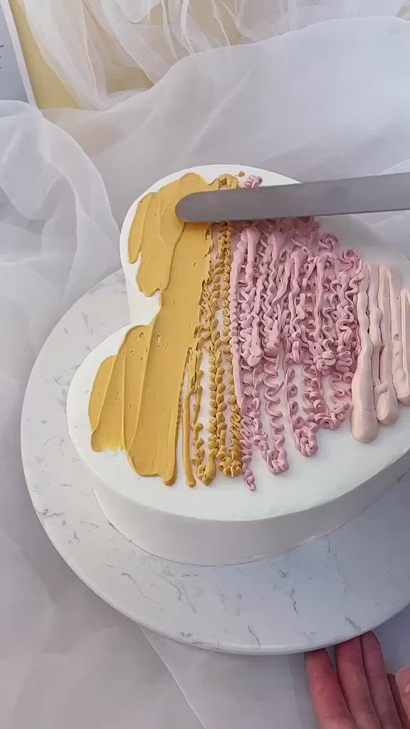 This may contain: there is a cake that has been decorated with pink and yellow icing on it