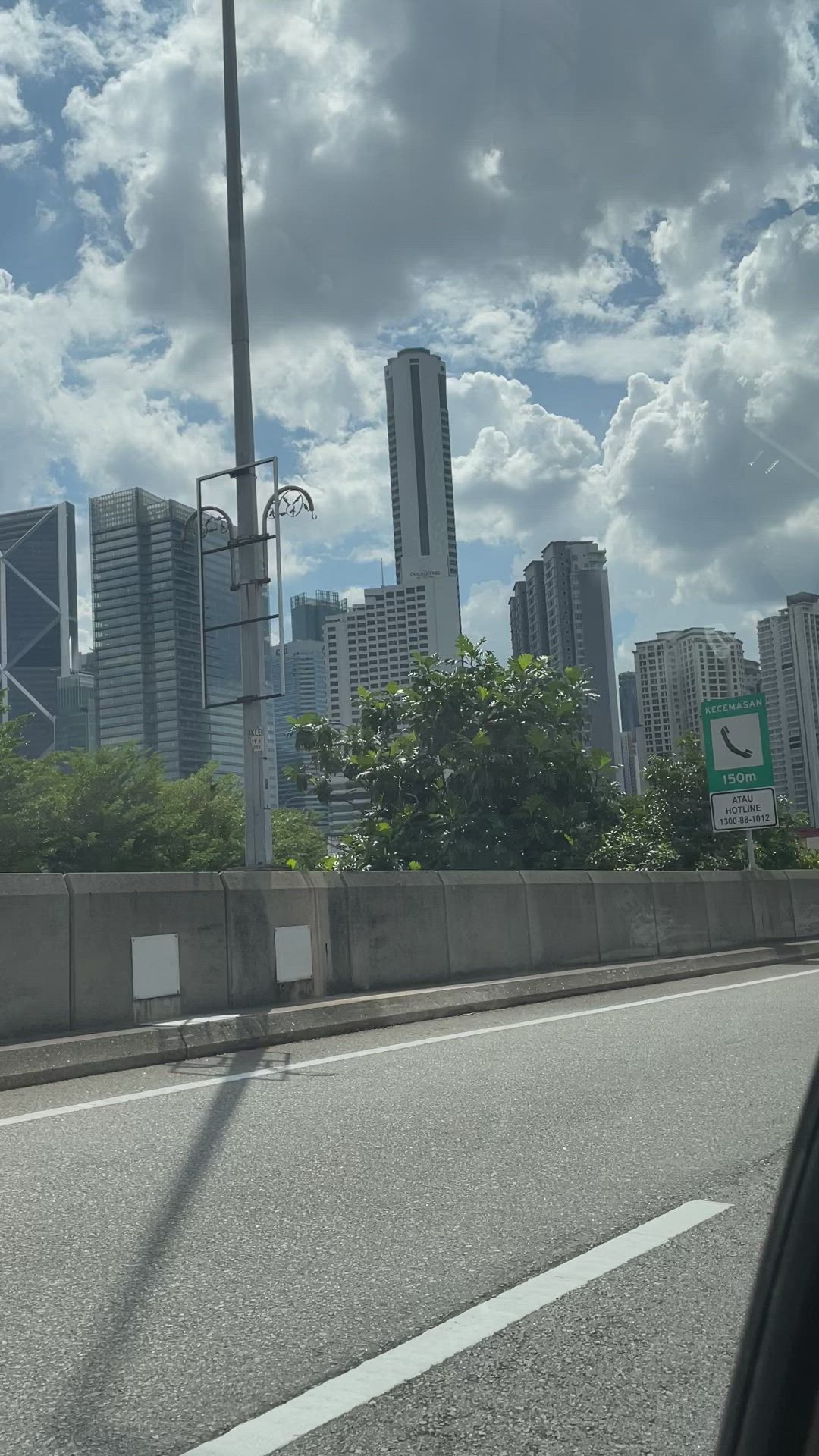 This may contain: the city skyline as seen from inside a car window, with clouds in the sky