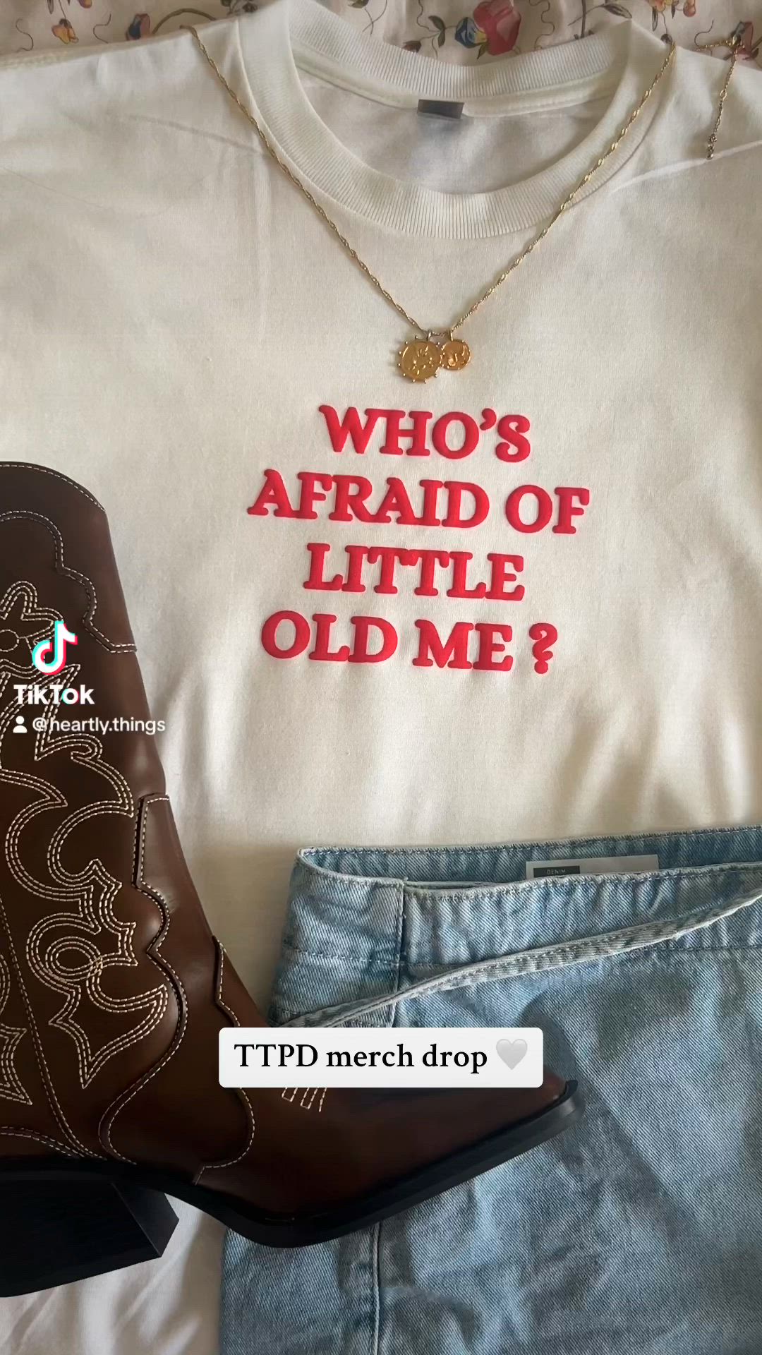 This may contain: a pair of jeans and cowboy boots are next to a t - shirt that says who's afraid of little old me?