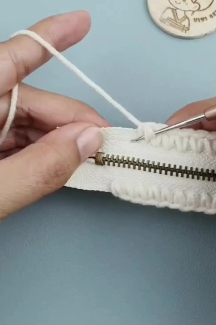 This may contain: someone is working with some thread on a piece of fabric that has been stitched together