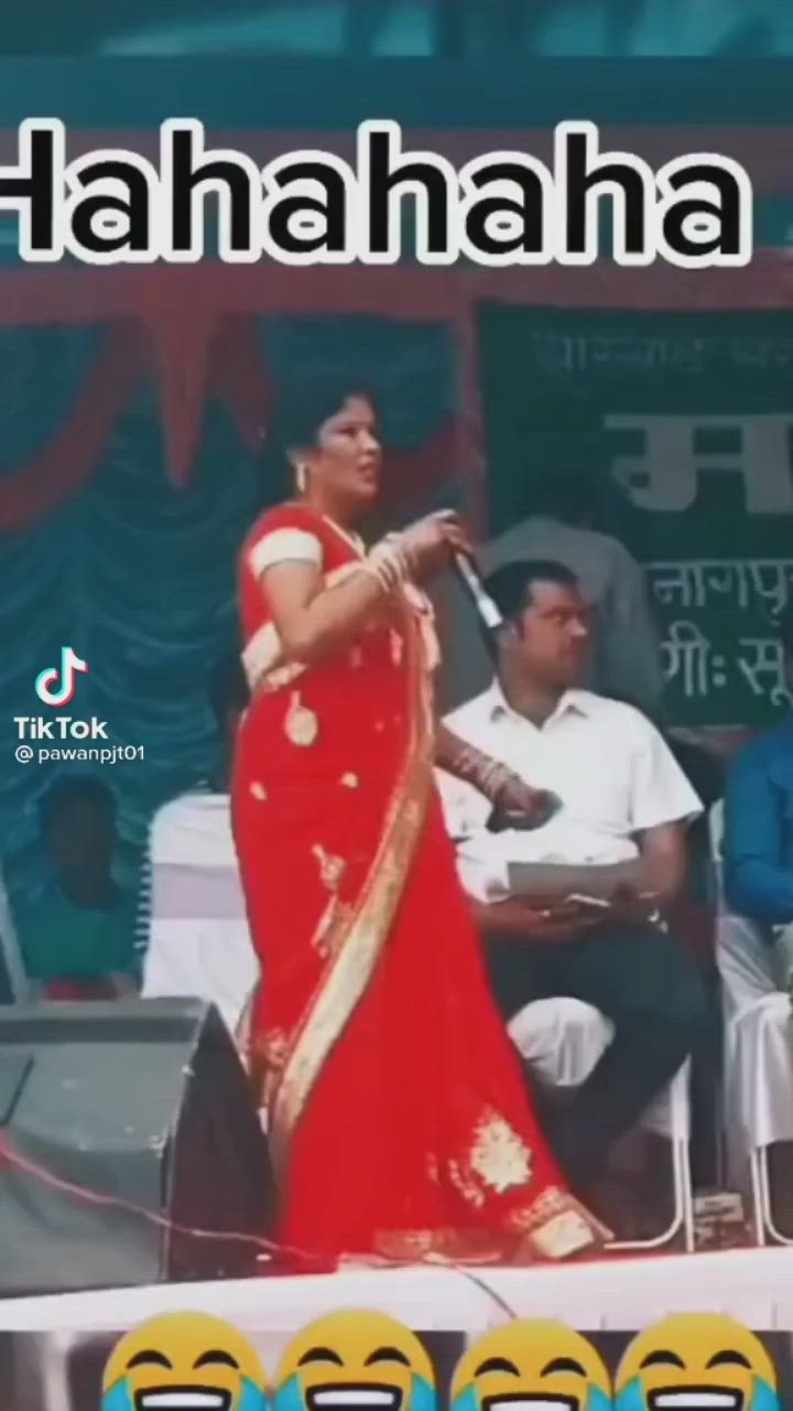 This may contain: a woman in a red sari is performing on stage with other people around her