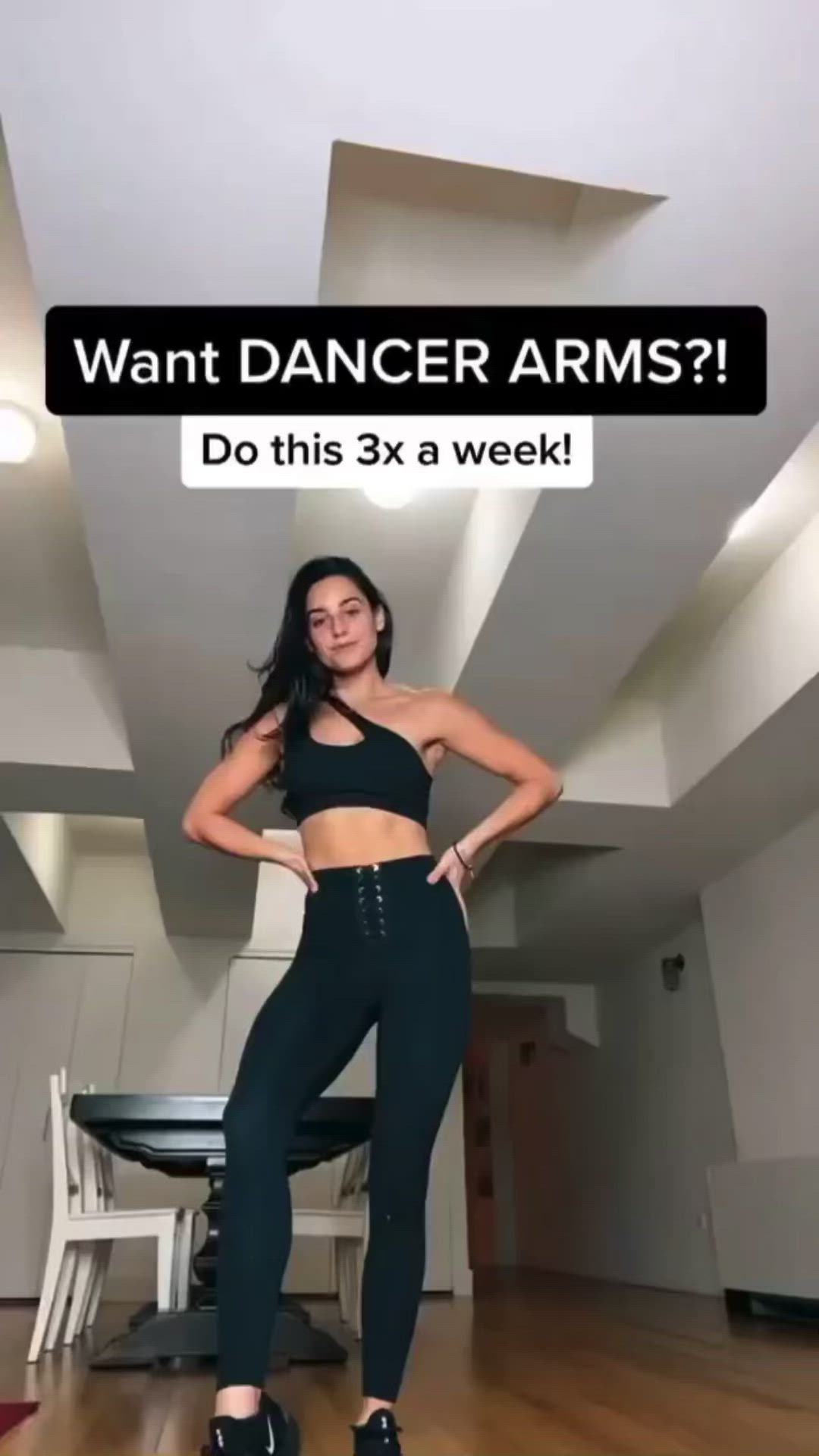 This may contain: a woman standing in a room with her hands on her hips and the words want dancer arms? do this 3x a week