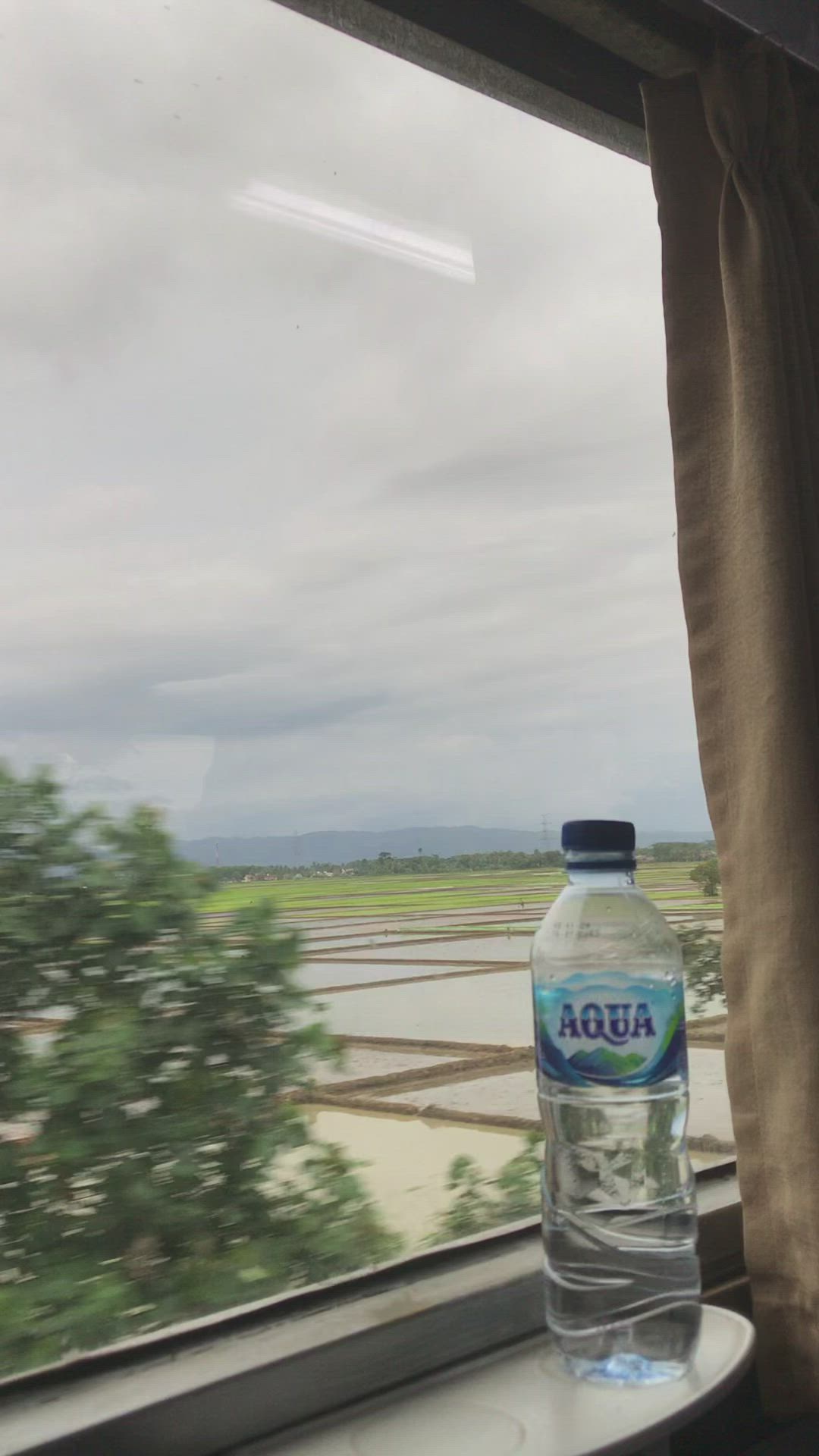 This may contain: a bottle of water sitting on top of a window sill