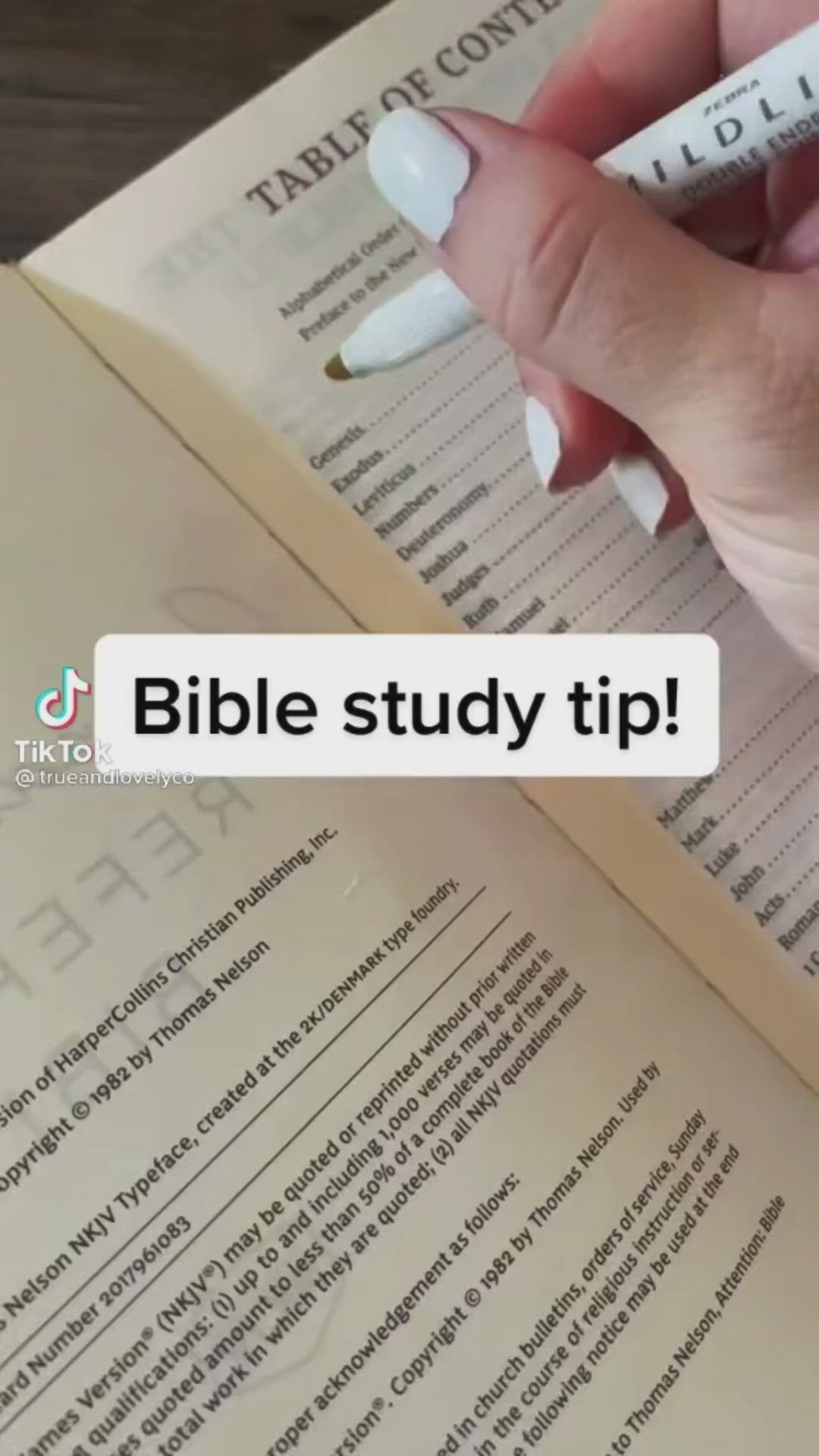 This may contain: a person is holding a pen and writing on a book with the words bible study tip