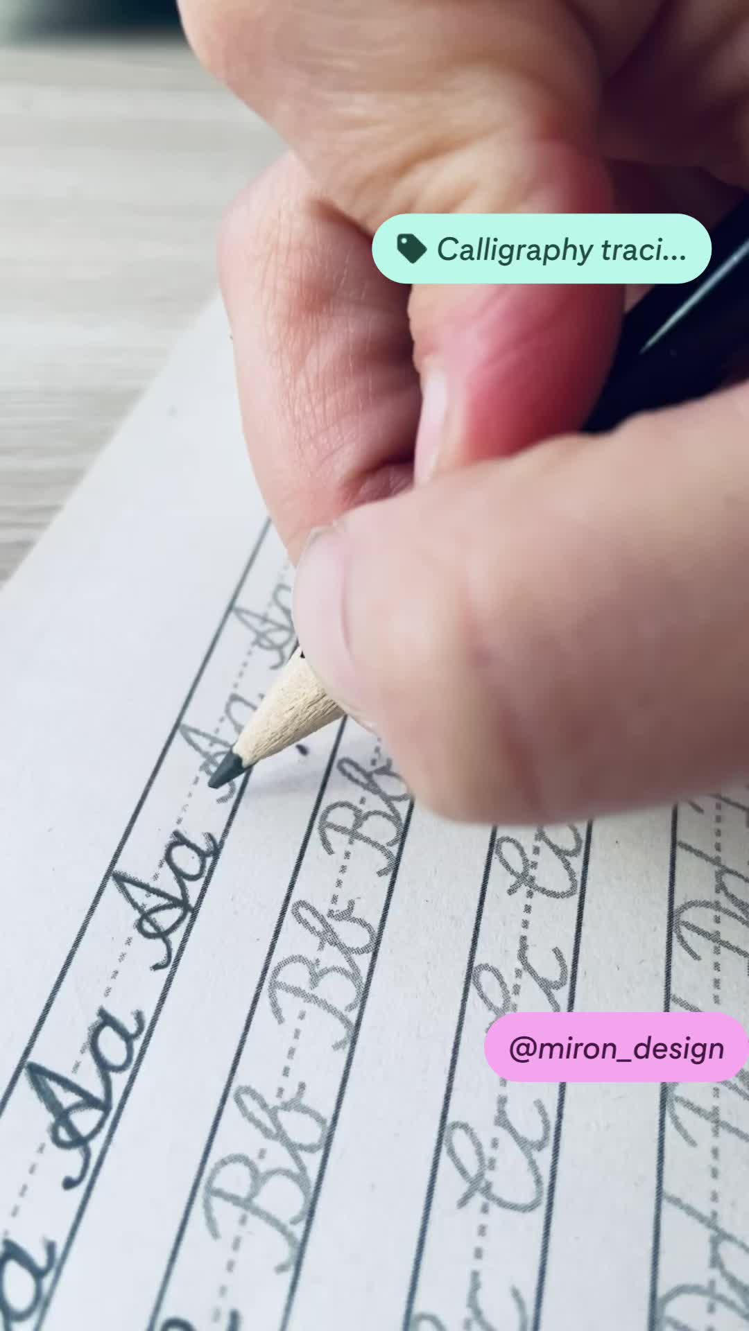 This may contain: someone is writing with a pencil on top of a piece of paper that says calligraphy track