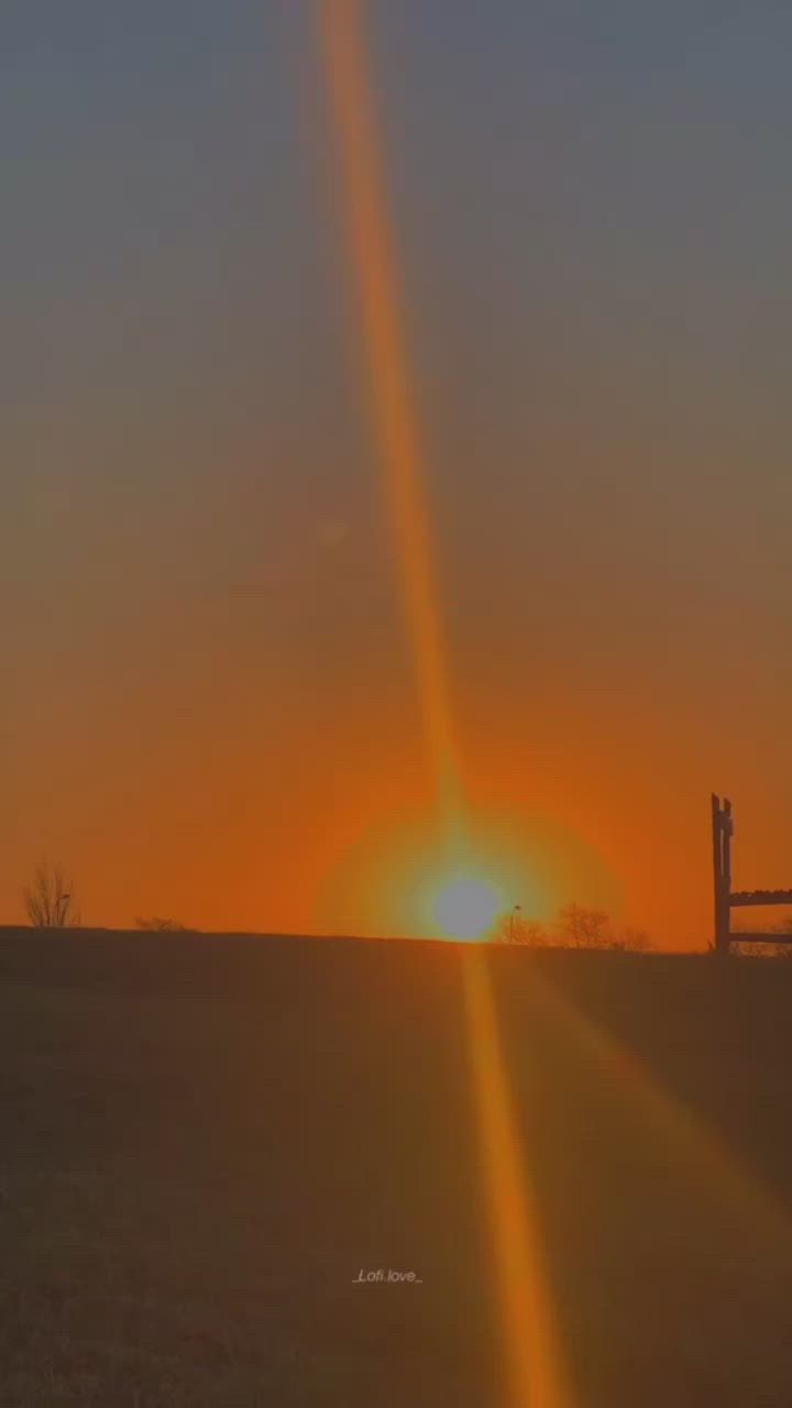 This may contain: two people walking away from the sun at sunset