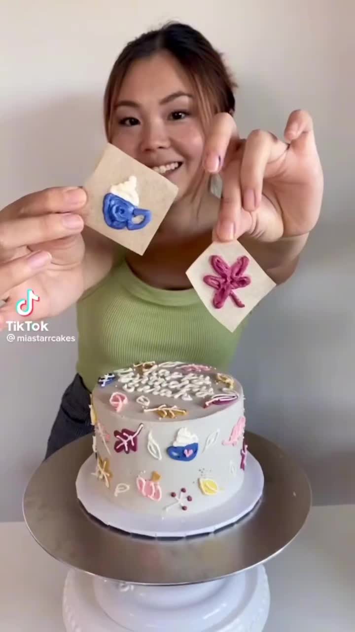 This may contain: a woman is holding up two cards to show off her cake