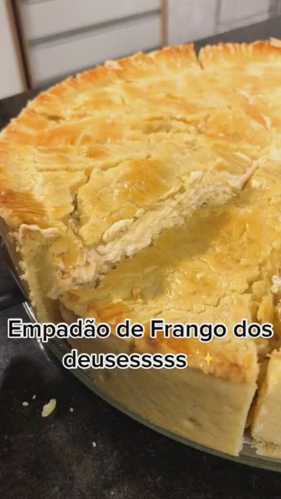 This may contain: a pie sitting on top of a metal pan covered in cheesecake toppings with the words empaddo de frango dos delesssso