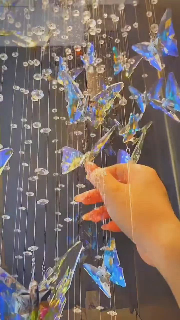 This may contain: a person is touching some glass butterflies