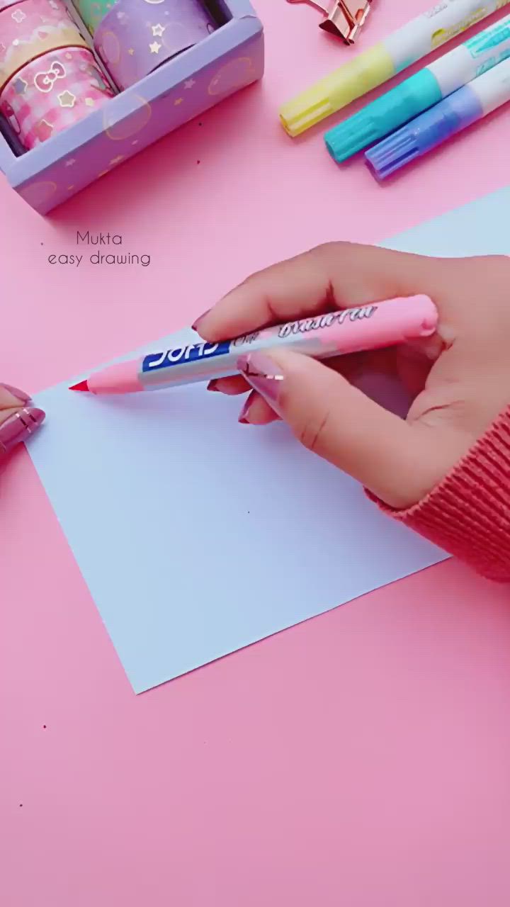 This may contain: a person is writing on a piece of paper with markers and pens in front of them