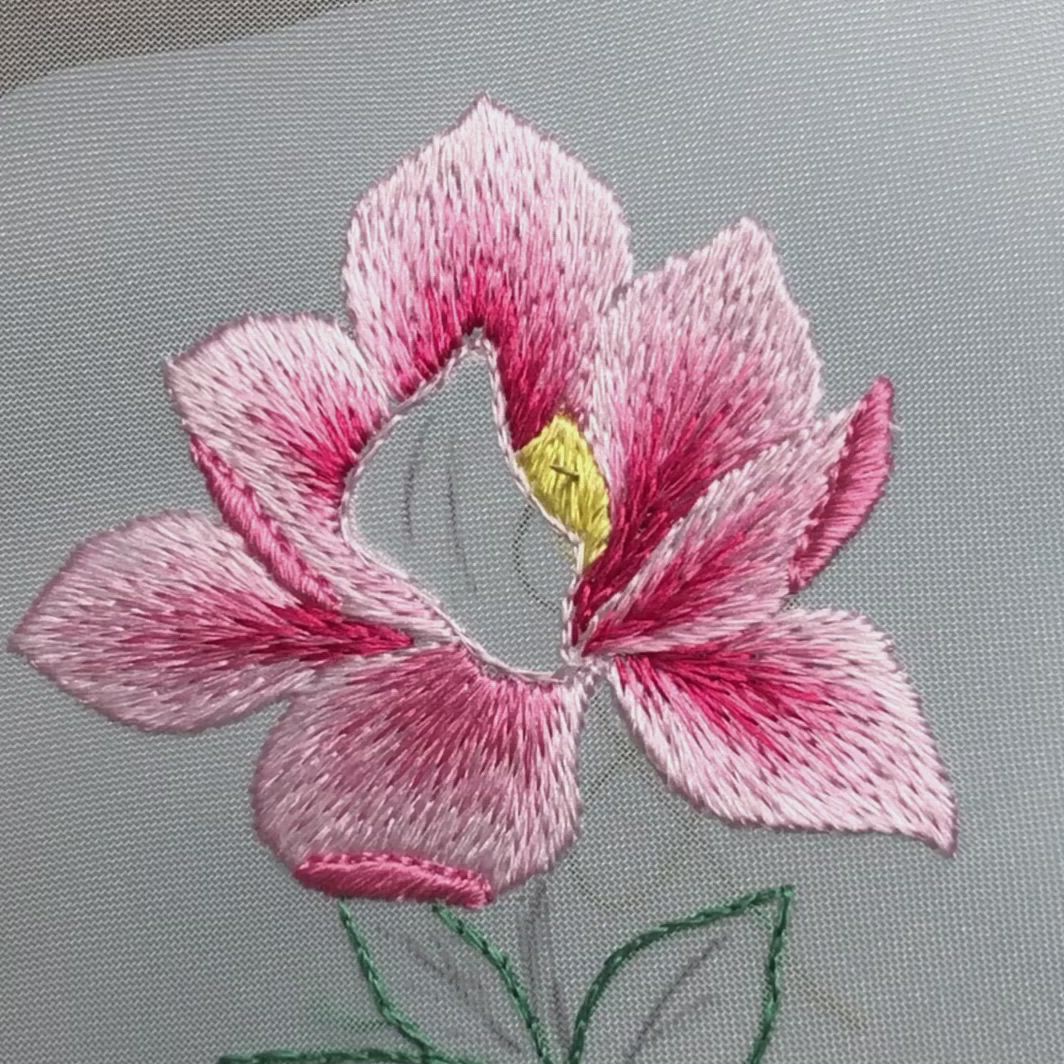 This may contain: a close up of a flower on a piece of cloth with stitching in the middle