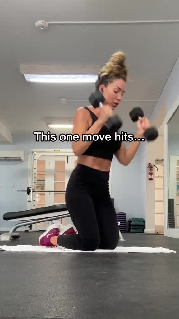 This may contain: a woman doing exercises with dumbbells in a gym