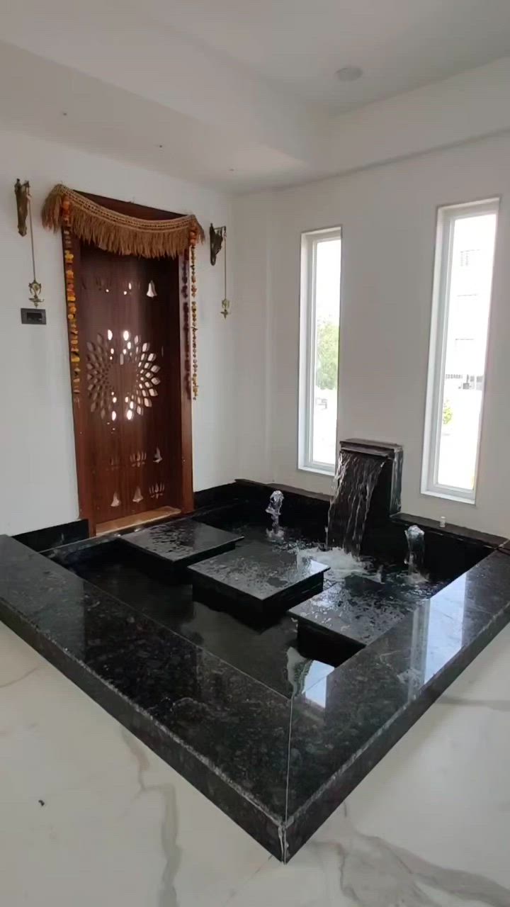 This may contain: a large black counter top in a room with two windows and a door behind it