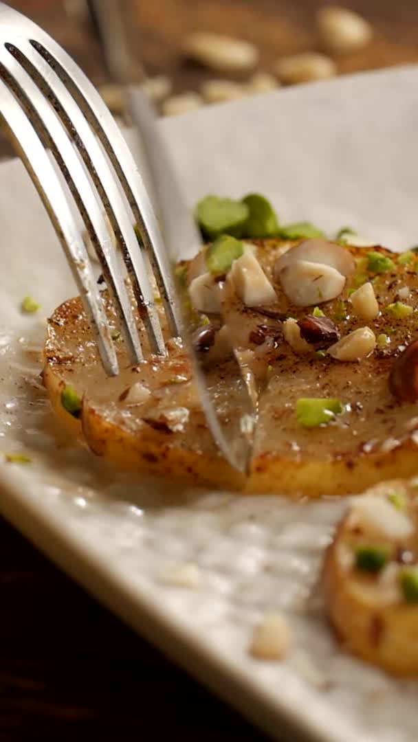 This may contain: a white plate topped with food on top of a wooden table next to a fork