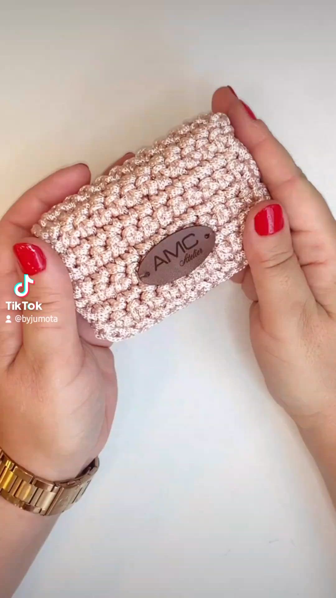 This may contain: two hands holding a crocheted purse with the word avc written on it