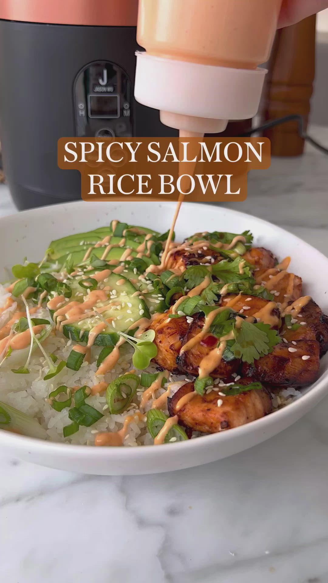 This may contain: a bowl filled with rice and vegetables next to an air fryer that says spicy salmon rice bowl