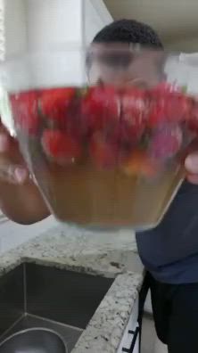 This may contain: a man holding a bowl full of strawberries in front of his face with the caption, weekly fruit bowls