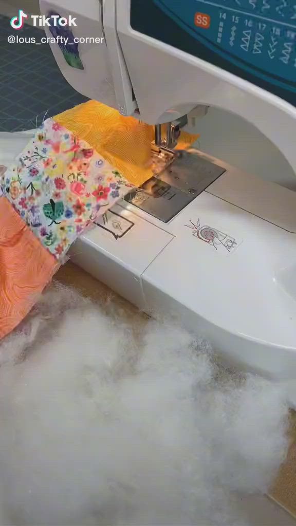 This may contain: someone is using a sewing machine to sew something on the floor covered in foam