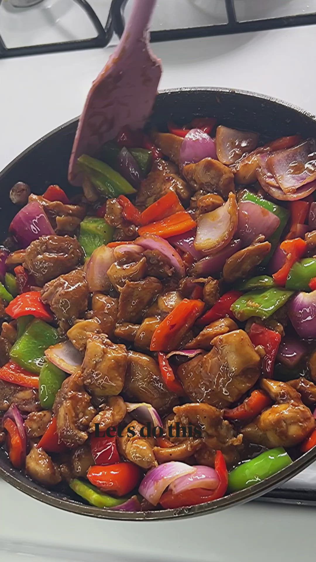 This may contain: a pan filled with meat and vegetables on top of a stove