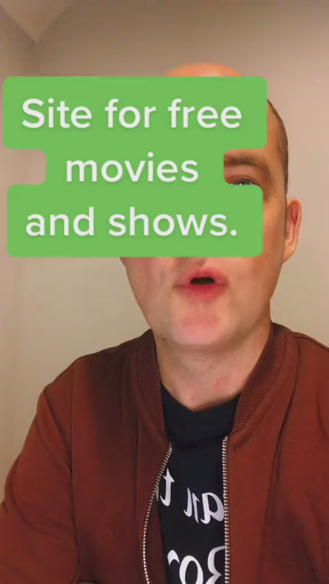 This may contain: a man holding up a green sign with the words site for free movies and shows