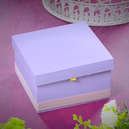 This may contain: a white box sitting on top of a purple table