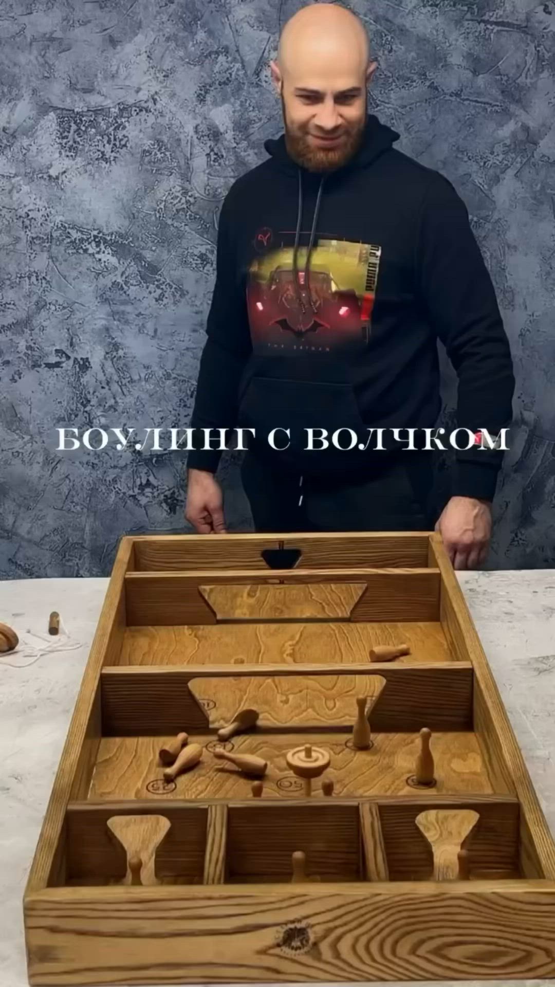 This may contain: a man standing in front of a wooden box