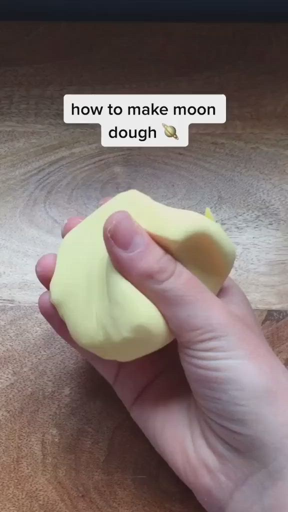 This may contain: a person holding something in their hand with the caption how to make moon dough